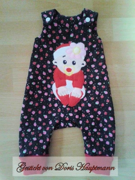 Preview: Baby sitzend mit Schnuller und Blumenmütze Preview: Baby sitzend mit Schnuller und Blumenmütze